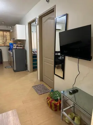 a living room with a flat screen tv on a wall at B-G Sorento Oasis 2BR in Manila