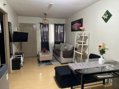 a living room with a couch and a table at B-G Sorento Oasis 2BR in Manila