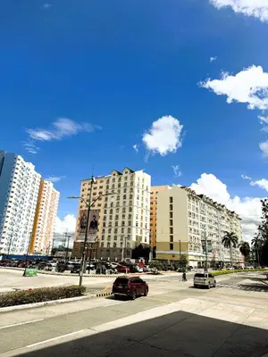 a street with cars parked in front of tall buildings at JFam Suites, C3-11D Studio, Up To 4 Pax in Biñan