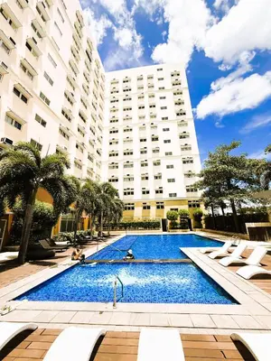 a swimming pool in front of a large building at JFam Suites, C3-11D Studio, Up To 4 Pax in Biñan