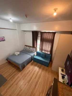 a small bedroom with a bed and a couch at JFam Suites, C3-11D Studio, Up To 4 Pax in Biñan