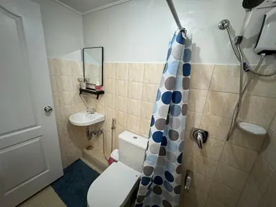 a small bathroom with a toilet and a shower at Condo in Pasig - One Oasis Staycation in Manila