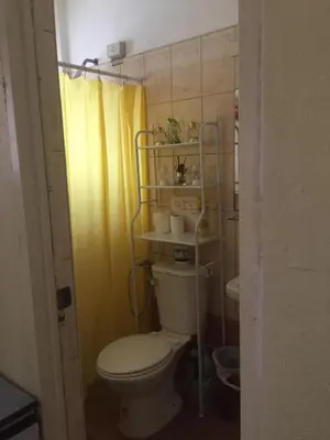 a bathroom with a toilet and a yellow shower curtain at Arcobaleno in Manila