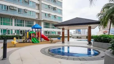 a playground in front of a large building at Makati Cozy Studio Apartment in Manila