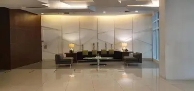 a lobby with chairs and a table in a building at Makati Cozy Studio Apartment in Manila