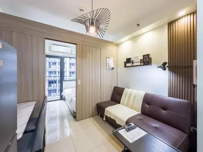 a living room with a couch and a bed at GemstoneBR in SMDC Shore 2 Residences in Manila