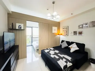 a bedroom with a bed and a flat screen tv at GemstoneBR in SMDC Shore 2 Residences in Manila