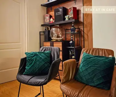 two chairs with green pillows in a living room at Cinema room at Intramuros by IN cafebar in Manila