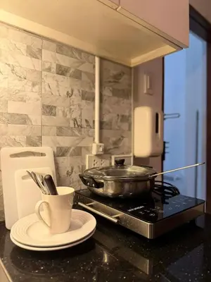 a kitchen counter with a pan on a stove and a plate at Cinema room at Intramuros by IN cafebar in Manila