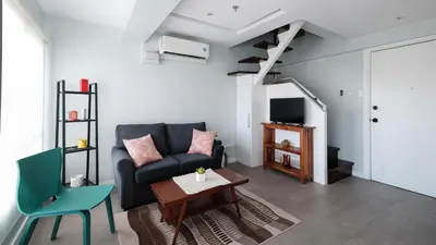 a living room with a couch and a table at One bedroom budget condo in BGC in Manila