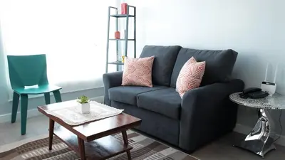 a living room with a blue couch and a table at One bedroom budget condo in BGC in Manila