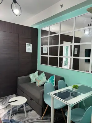 a living room with a couch and a table at Cozy Condo Apartment in Makati / Manila with mall, restaurants, groceries, pool, netflix, disney+ and more in Manila