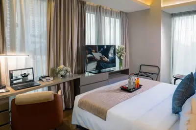 a hotel room with a bed and a flat screen tv at Oakwood Makati Avenue in Manila
