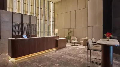 a lobby with a waiting area with a table and chairs at Oakwood Makati Avenue in Manila