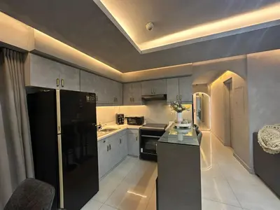 a kitchen with a black refrigerator and a stove at Condo in Taguig, 2br condo, Acacia Estates, BGC, in Manila