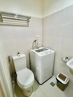 a white bathroom with a toilet and a sink at Sea Residences: Eyal’s Suite Condotel near MOA/Mall of Asia in Manila
