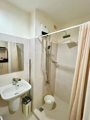 a bathroom with a sink and a toilet and a shower at Sea Residences: Eyal’s Suite Condotel near MOA/Mall of Asia in Manila