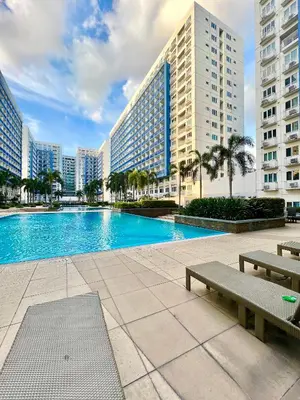 a large swimming pool in a city with buildings at Sea Residences: Eyal’s Suite Condotel near MOA/Mall of Asia in Manila