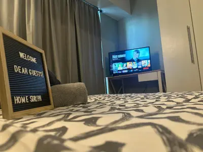 a hotel room with a sign on a bed and a tv at DFT Apartment 