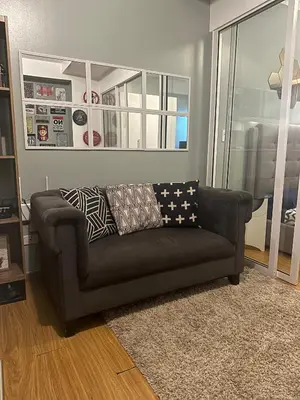 a brown couch in a living room with a window at DFT Apartment 