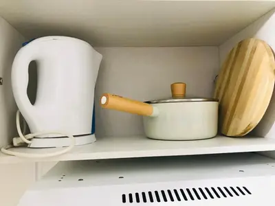 a shelf with various kitchen items on it at Spring Residences Affordable Condotel Bicutan Paranaque near NAIA Airport in Manila