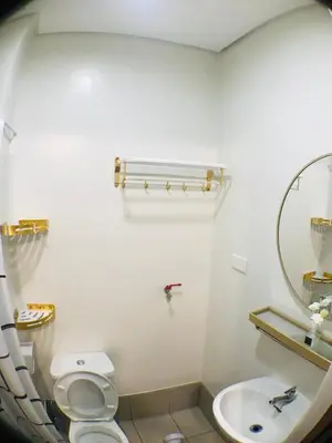a bathroom with a sink and a toilet and a mirror at Spring Residences Affordable Condotel Bicutan Paranaque near NAIA Airport in Manila