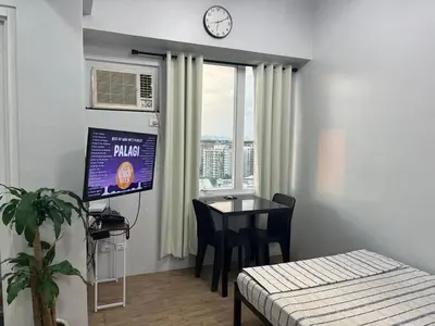 a room with a table and a clock on the wall at Ultimate getaway in Alabang at Anuva Residences in Manila