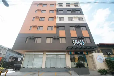 a tall building with a sign on it at Sans Hotel at One JD Place Makati by RedDoorz in Manila