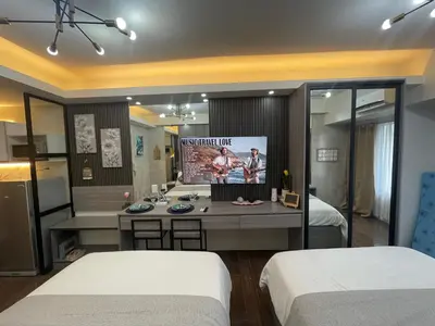 a room with two beds and a tv in it at Cozy Family Nook at Makati in Manila