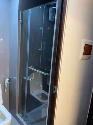 a bathroom with a glass shower with a toilet at Cozy Family Nook at Makati in Manila