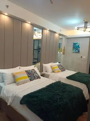 a bedroom with two beds with green blankets on them at Cozy Family Nook at Makati in Manila