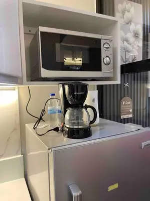 a microwave and a blender on top of a refrigerator at Cozy Family Nook at Makati in Manila