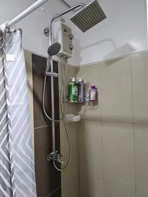 a shower with a shower head in a bathroom at Jamellas' Smile Home in Manila