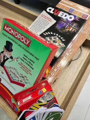 two boxes of monopoly sitting on a wooden table at Jamellas' Smile Home in Manila