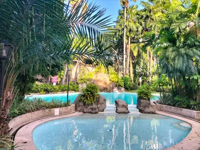 a pool at a resort with palm trees at Nathan's Staycation in Manila