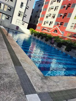 a swimming pool in the middle of two buildings at Nathan's Staycation in Manila