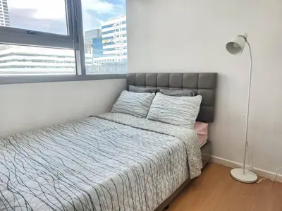 a bedroom with a bed and a large window at BGC Avant at The Fort Cosy and Vibrant 2BR near Burgos Circle in Manila
