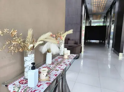 a table with vases and flowers on it in a hallway at BGC Avant at The Fort Cosy and Vibrant 2BR near Burgos Circle in Manila
