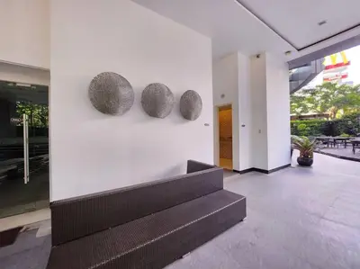 a lobby with a bench and three sculptures on a wall at BGC Avant at The Fort Cosy and Vibrant 2BR near Burgos Circle in Manila