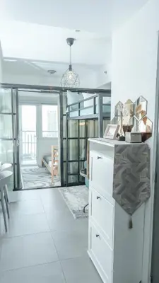 a living room with white cabinets and a large window at Casa Roma Manila in Manila