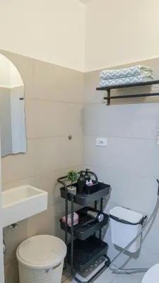 a bathroom with a sink and a toilet and a mirror at Casa Roma Manila in Manila