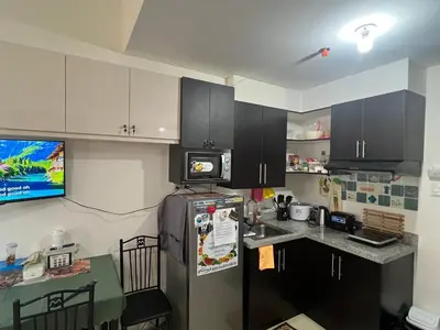a kitchen with a refrigerator and a counter top at Relaxing Haven at Covent Garden in Manila