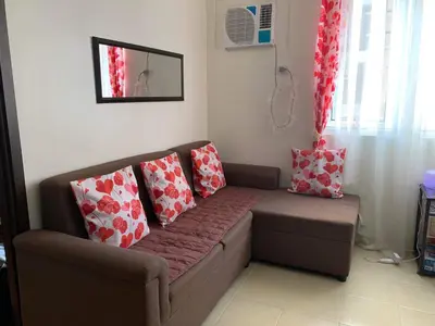 a couch with pillows on it in a living room at Relaxing Haven at Covent Garden in Manila