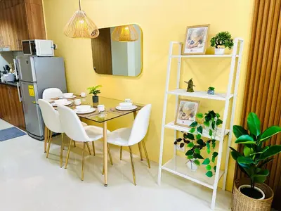 a dining room with a table and white chairs at Chic and Cozy 1BR Shore 3 by SMDC near MOA in Manila