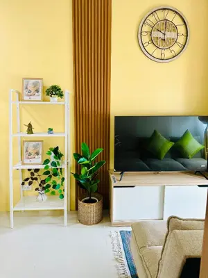 a living room with a couch and a clock on the wall at Chic and Cozy 1BR Shore 3 by SMDC near MOA in Manila
