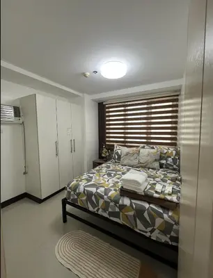 a bedroom with a bed and a window at 2BR Staycation in front of MOA Near Aiports Entertainment City Ayala Malls Parqal Worldtrade Center PICC Starcity SEA ESCAPE BLISS in Manila