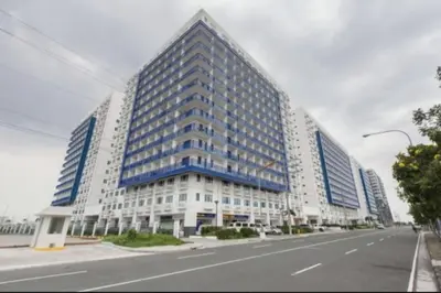 a large building with blue windows on a city street at 2BR Staycation in front of MOA Near Aiports Entertainment City Ayala Malls Parqal Worldtrade Center PICC Starcity SEA ESCAPE BLISS in Manila