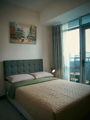 a bedroom with a large bed and a window at The Bat Cave 2 at Manhattan Heights Araneta Cubao in Manila