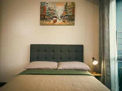 a bedroom with a bed with a picture on the wall at The Bat Cave 2 at Manhattan Heights Araneta Cubao in Manila