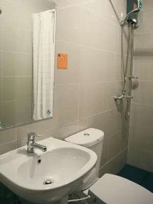 a bathroom with a sink and a toilet and a mirror at The Bat Cave 2 at Manhattan Heights Araneta Cubao in Manila